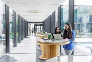 Motivierte Mitarbeiter, zufriedene Kunden / 2 Mitarbeiterinnen arbeiten am Laptop